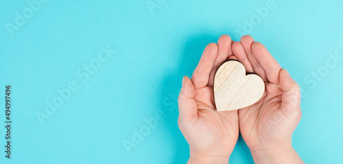 Woman is holding a red heart in her hand  blue colored background  copy space  love and charity symbol  hope concept 