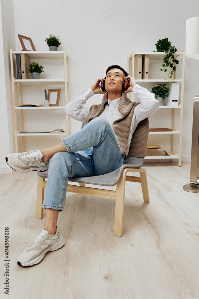 handsome man sweater on the shoulders headphones music sitting in the room technologies handsome man sweater on the shoulders headphones music sitting in the room technologies