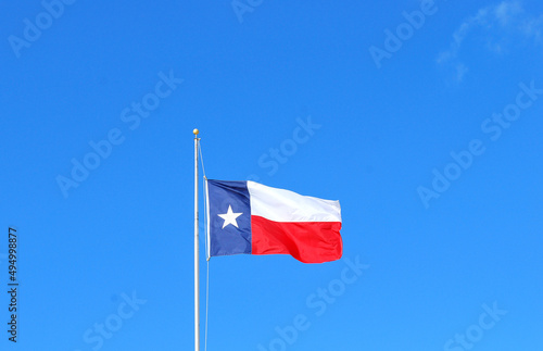 Texas flag flying high in the sky outdoors.