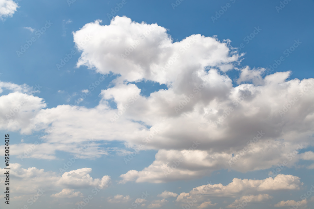 Fototapeta premium White clouds float across the blue sky over the yellow steppe land