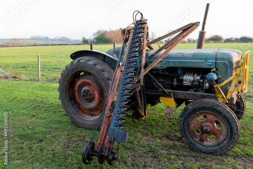 An antique cutter bar hedge trimmer mounted on a vintage tractor photo