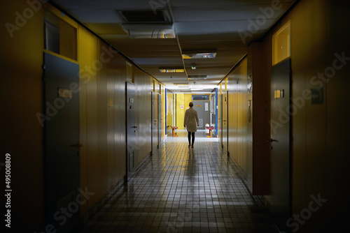 An institution employee walking a hallway. Institution  hallway  university