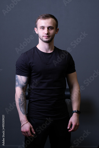 A guy standing in a black T-shirt is a beautiful sexy athlete handsome black man shirt blank, for healthy chest for young from muscular people, isolated sporty. Macho fashion standing, power adult © Ilya