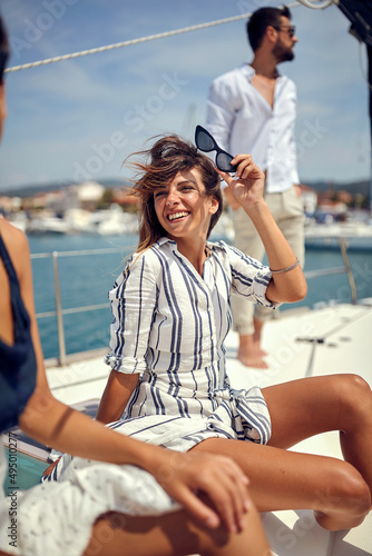 A young beautiful girl is enjoying with her friends while riding on a yacht on the seaside. Summer, sea, vacation, friendship © luckybusiness