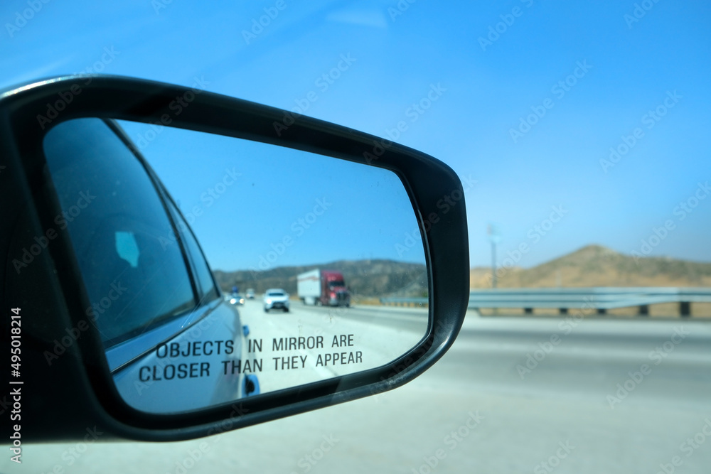 Image through the rearview mirror of a car with the inscription 