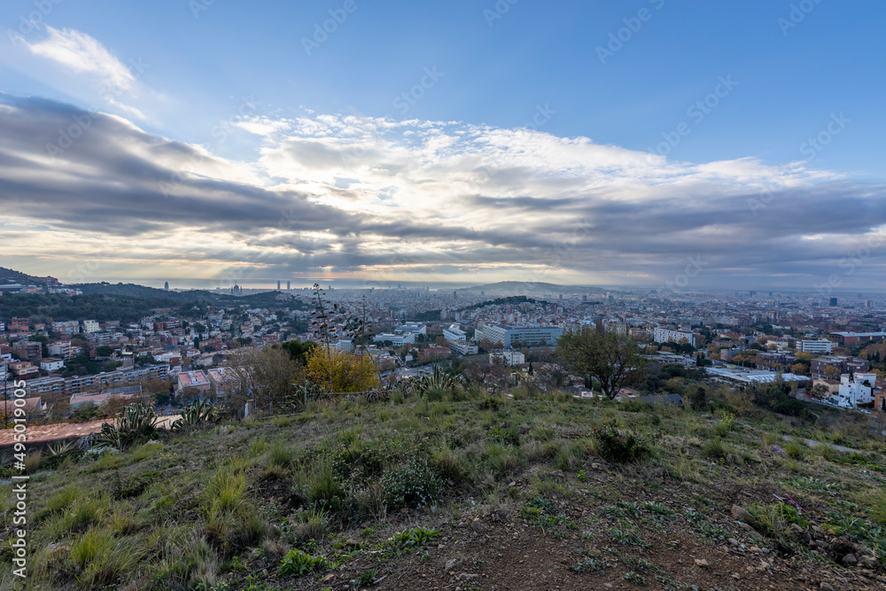 Obraz premium Panorama of Barcelona from the air in the early morning. City with shadows from the clouds. Dramatic sky over the city. Autumn in Barcelona, Spain.