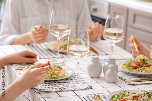Women eating delicious pasta at table