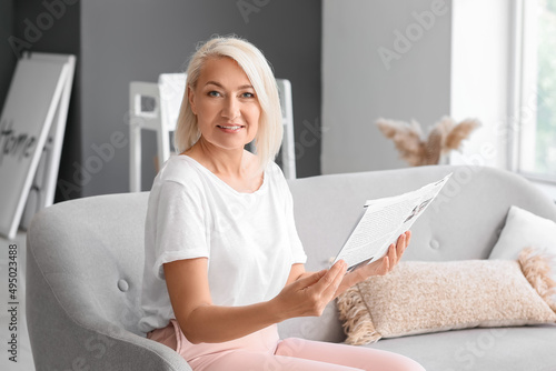 Mature woman reading newspa...
