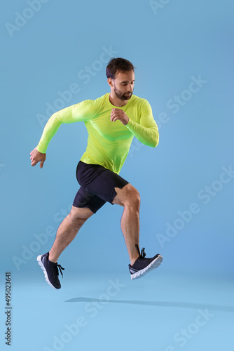Sporty male runner on color...