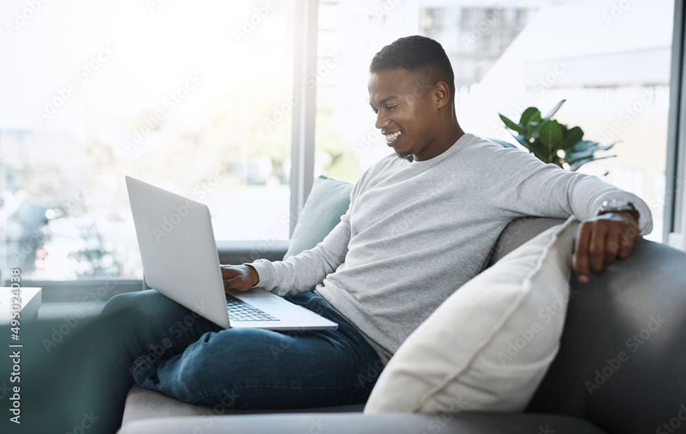 Where do I sign up for this content. Shot of a handsome young man using his laptop while sitting on a sofa at home. Where do I sign up for this content. Shot of a handsome young man using his laptop while sitting on a sofa at home.