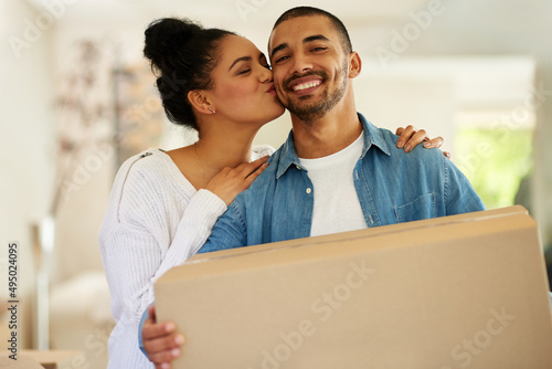 Taking their relationship to a whole new level. Portrait of a happy young couple carrying cardboard boxes into their new home. © Camerene P/peopleimages.com