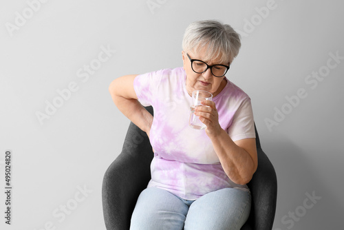 Senior woman with glass of ...