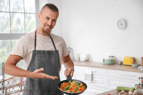 Young man showing frying pa...