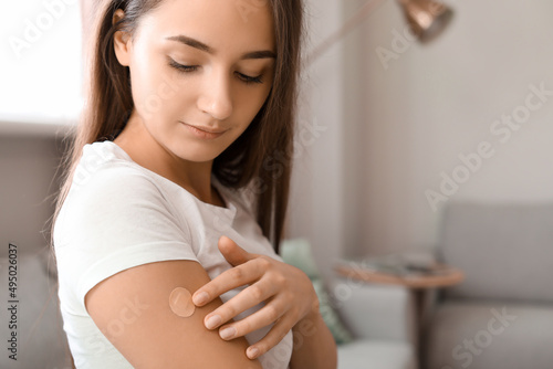 Young woman with applied nicotine patch at home. Smoking cessation photo