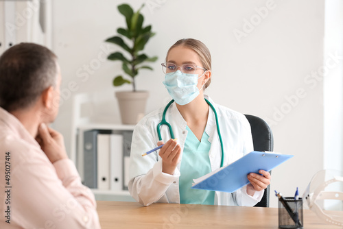 Ill man with sore throat visiting doctor in clinic