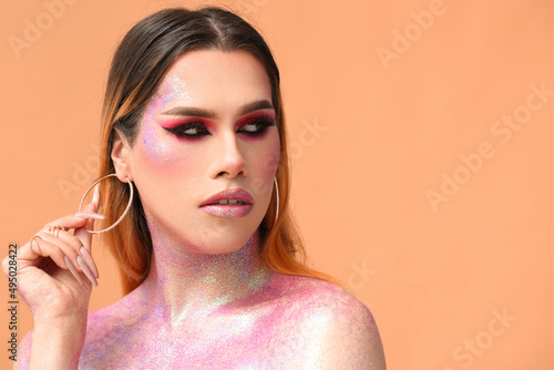 Quadro su tela Fashionable young transgender woman with glitters on body against color backgrou