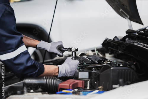 Professional mechanic working on the engine of the car in the garage. Car repair service.