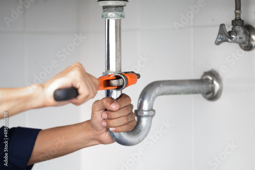 plumber at work in a bathroom, plumbing repair service, assemble and install concept.