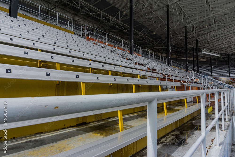 Large yellow and white shot of the bleachers with safety pole up close.