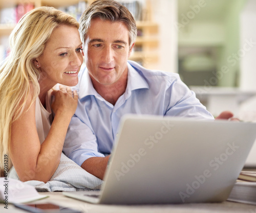 Everything they need to find at a click. Shot of a mature couple lying on their living room floor doing some online research. © Yuri Arcurs/peopleimages.com