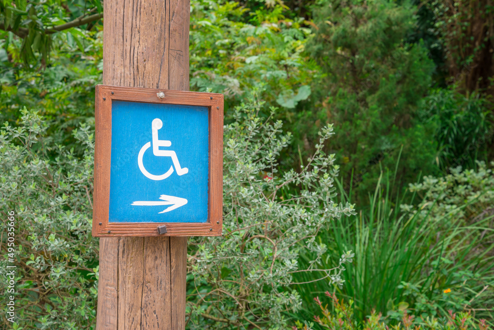 Wheelchair Handicap toilet direction sign in green park. Wheelchair Handicap toilet direction sign in green park.