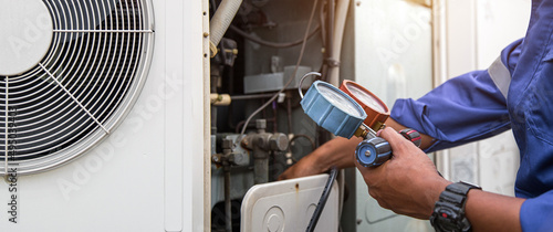 Foto Heat and Air Conditioning, HVAC system service technician using measuring manifold gauge checking refrigerant and filling industrial air conditioner after duct cleaning maintenance outdoor compressor