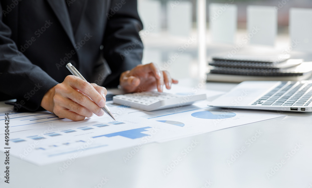 Close up of businesswoman Accounting using calculating income-expenditure and analyzing real estate investment data report Financial and tax systems concept. Close up of businesswoman Accounting using calculating income-expenditure and analyzing real estate investment data report Financial and tax systems concept.