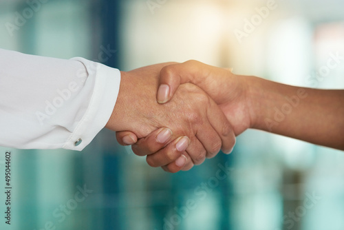 Lets shake on new beginnings. Cropped shot of two businesspeople shaking hands in an office.