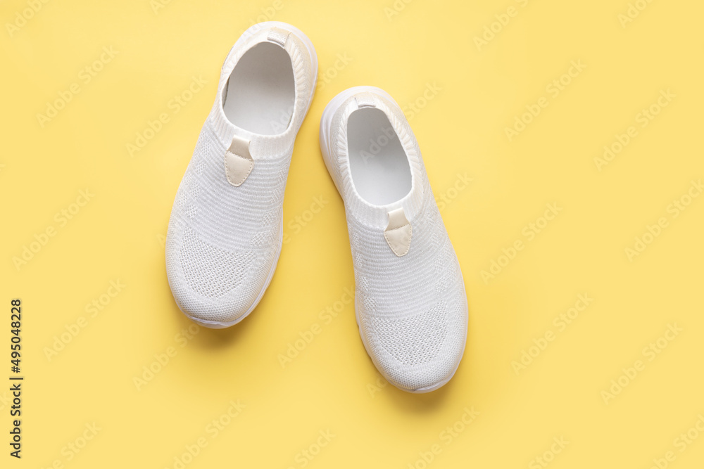 white women's sneakers on a yellow background white women's sneakers on a yellow background