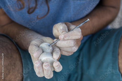 Male hands carve stone sculpture in India,
