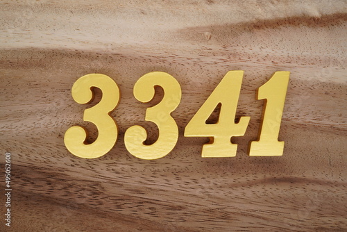 Golden Arabic numerals on a real brown and white wooden floor number 3341 photo