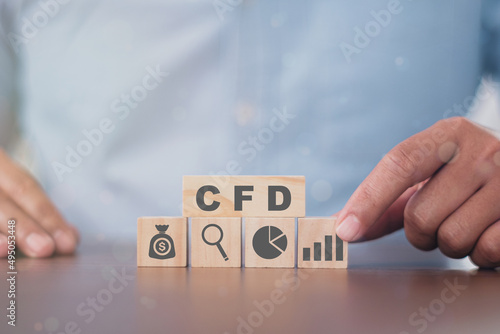 Business man puts the wooden cube with success icon CFD. Contract for difference financce technology stock market concept.