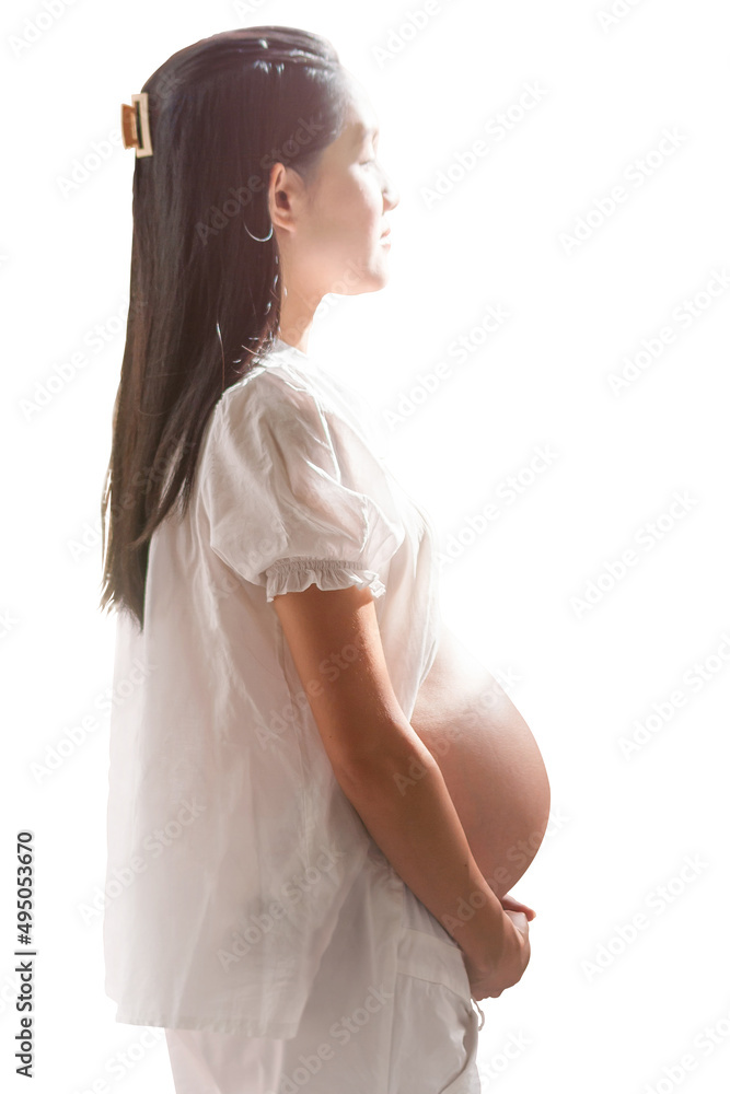 Thai (Asian) woman, 7 months pregnant, standing sideways with the light shining down upon and clipping path Thai (Asian) woman, 7 months pregnant, standing sideways with the light shining down upon and clipping path