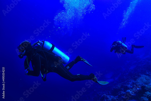 divers underwater at depth in the blue sea background