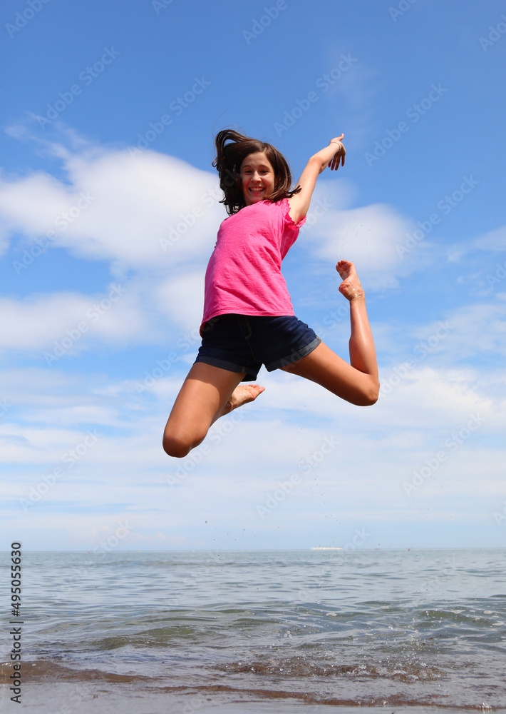 young smiling girl makes a jump symbol of happiness and much optimism young smiling girl makes a jump symbol of happiness and much optimism