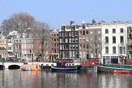 Amsterdam Amstel River View with Houseboats, Bridge and Historic Architecture, Netherlands