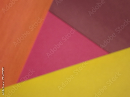 Background surface made of green, red, crimson, orange and yellow paper