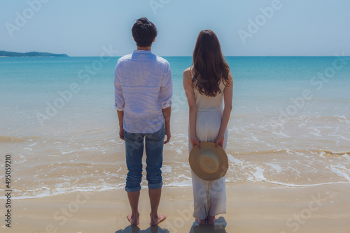海を眺めるビーチに立つカップルの後姿