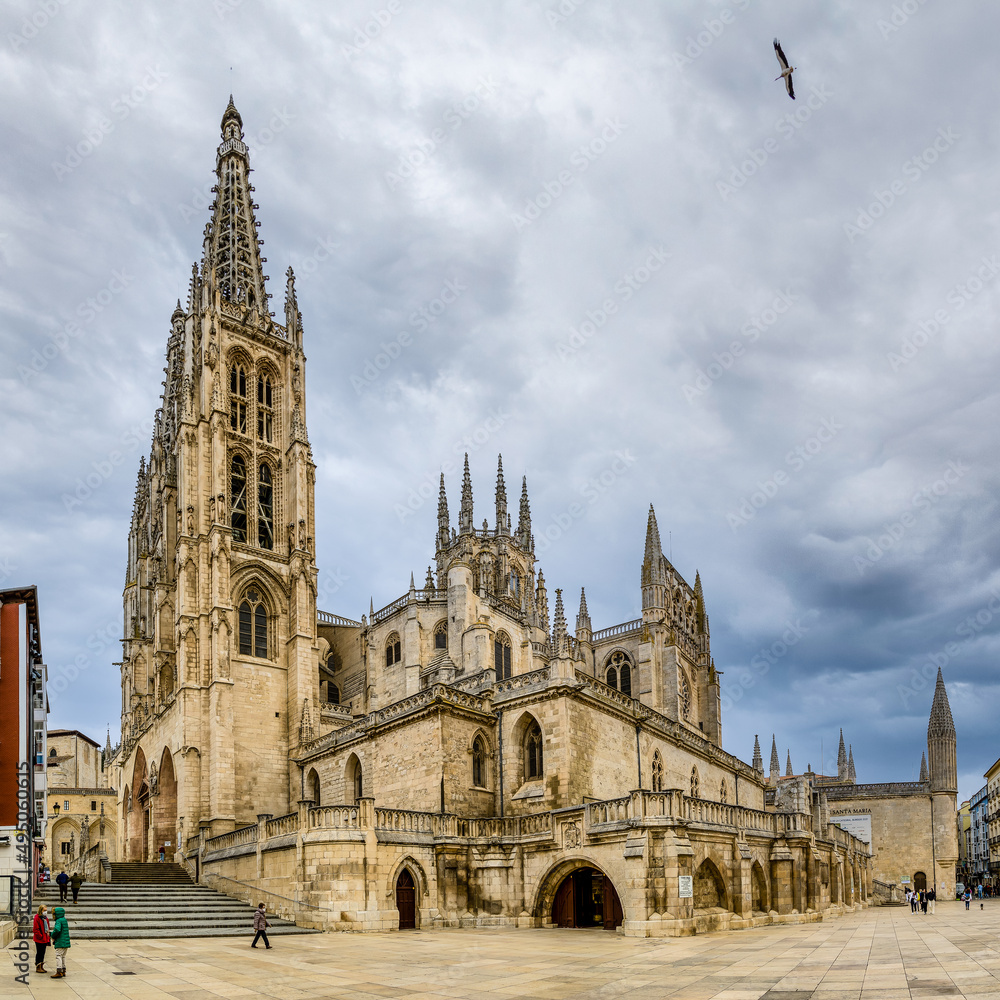 Burgos Cathedral with people and tourists walking past in the square next to the Cathedral of Saint Mary