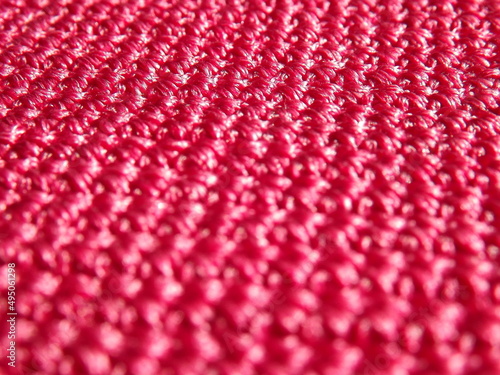Knitted fabric of pink, crimson color close-up as a background