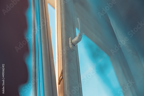 Tableau sur toile View from below to white plastic open window frame at sunset