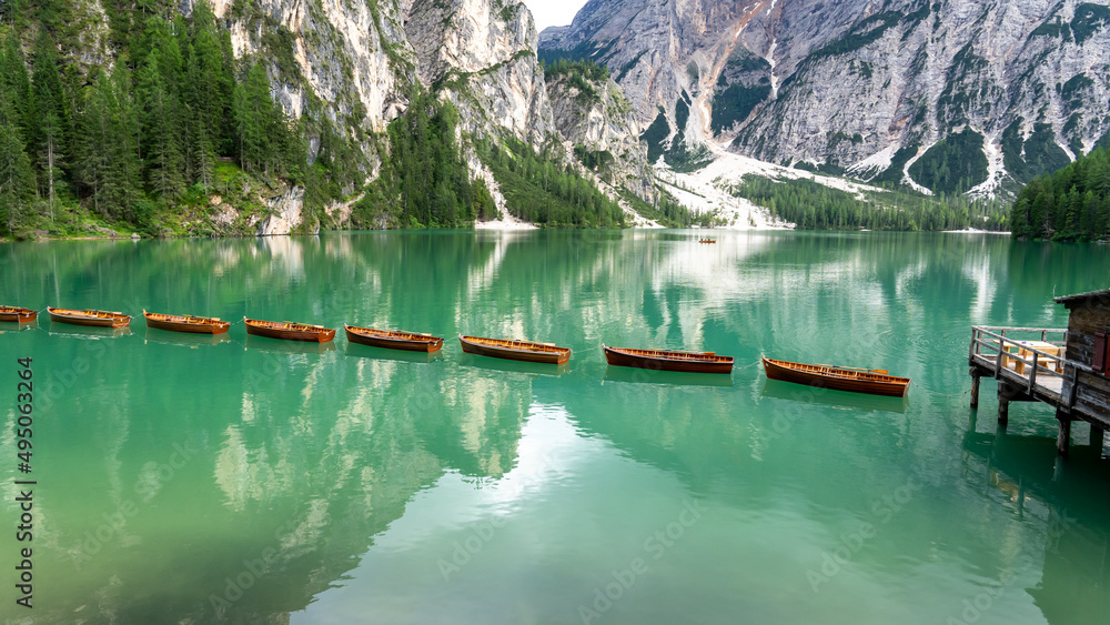 Amazing view of the famous Braies Lake in Italy. Typical rowing boats made of wood. Alpine lake. Iconic location for photographers. Picturesque mountain lake in Dolomites. Wonderful nature contest