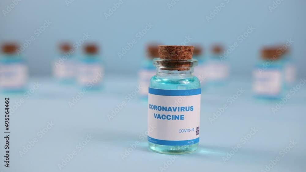 Syringe needle, a drop liquid, blurred pfizer company on the blue background. Coronavirus vaccine concept. Covid-19 inoculation jointly developed. Ready-made preparations with doses Syringe needle, a drop liquid, blurred pfizer company on the blue background. Coronavirus vaccine concept. Covid-19 inoculation jointly developed. Ready-made preparations with doses