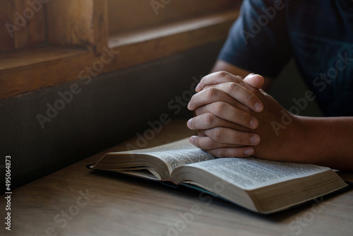 prayer for blessings to god Christian life Man sitting and praying for God's blessings for a better life Human hands praying to God with scriptures on the windowsill. with the light shining down