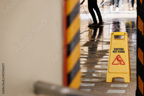 caution wet floor sign on public footpath. photo