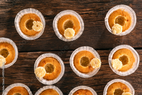 Cooling freshly baked muffins on wooden background. Top view. Process of making cupcakes with filling.