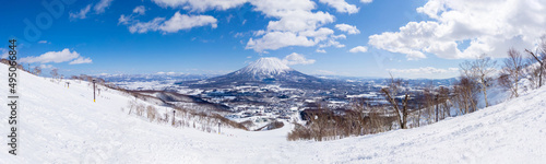 Panoramic view of snowy volcano and town seen from a ski resort (Niseko, Hokkaido, Japan) photo