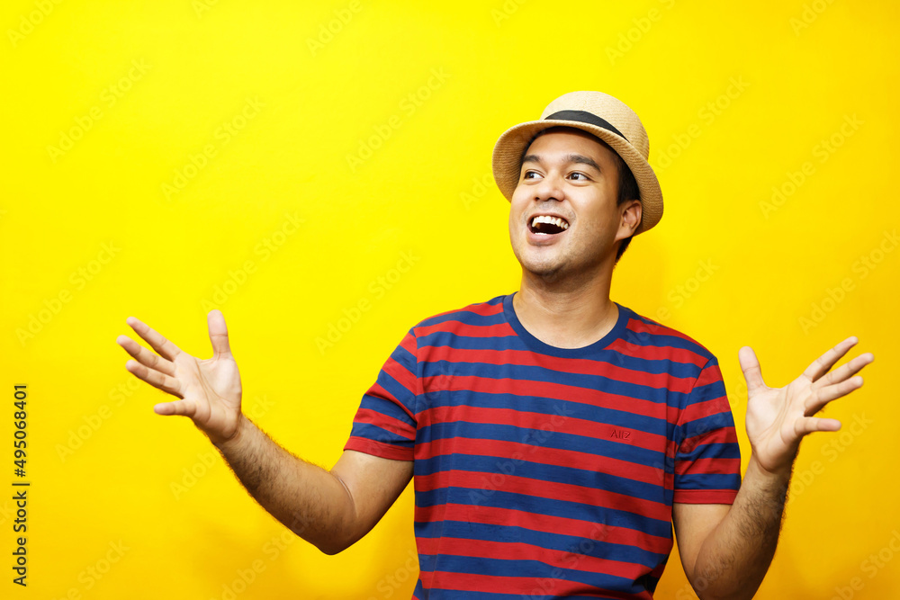 Portrait of Hipster young man young happy man casual dress red striped t-shirt and wear a hats. Gesture emotion extend the arms shy modest on studio portraits set color yellow background.