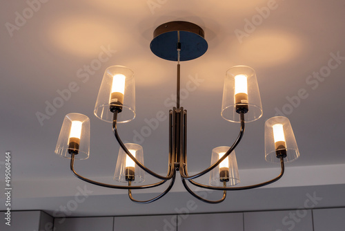 Chandelier hanging from the ceiling with lights on