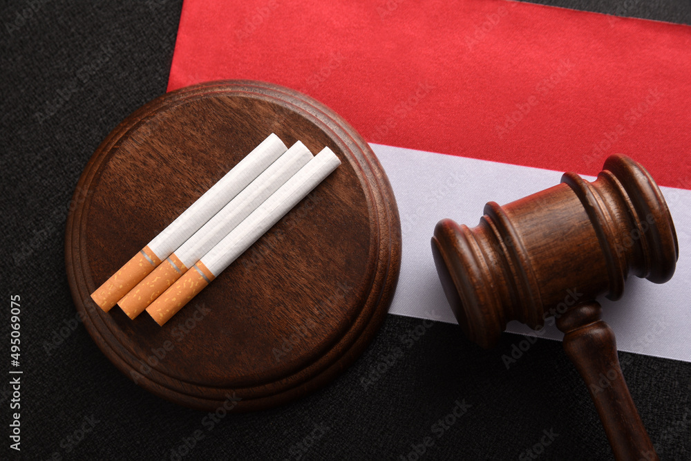 Cigarettes, wooden Judge gavel and flag of Indonesia. Tobacco control act. Top view. Justice and Tobacco law. Government duty. Illegal import.